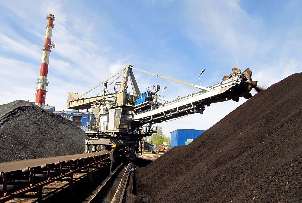 Stacker with a heap of coal next to the plant