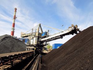 Stacker with a heap of coal next to the plant